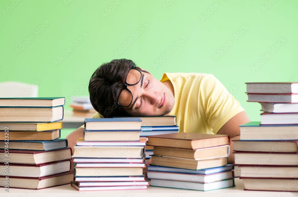 Student with too many books to read before exam Student with too many books to read before exam