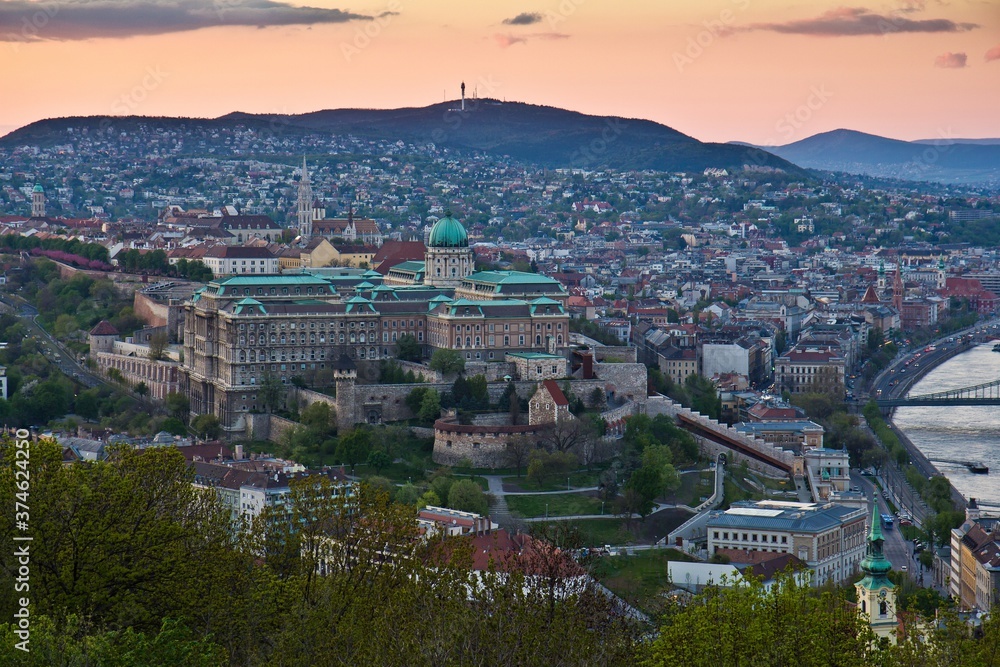 View from the Gellert Hill of the massive Royal Palace (extended in the 14th century) surrounded with historical buildings. Evening, twilight. Budapest, Hungary.