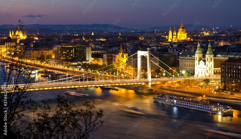 Fototapeta premium View from Gellert hill of night Danube river, Elizabeth Bridgewith lights and Pest part of the city with Sziget's Eye (ferris wheel) and St. Stephen's Basilica. Budapest, Hungary..