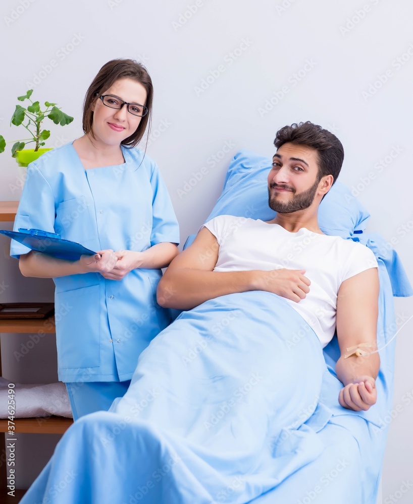 Woman doctor examining male patient in hospital Woman doctor examining male patient in hospital