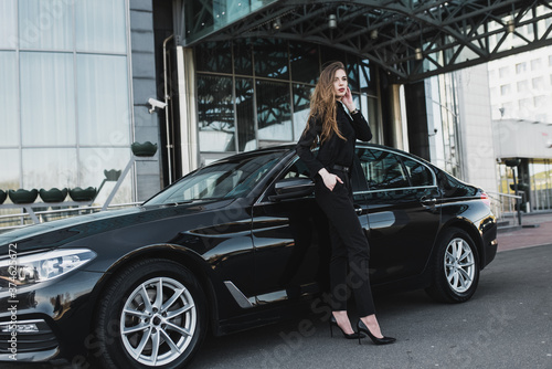 Young businesswoman in black wear with a expensive car © Ivan Zelenin