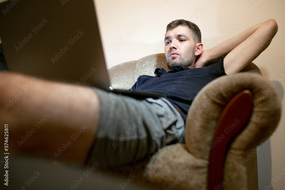 The guy works for a laptop and a phone at a remote work The guy works for a laptop and a phone at a remote work