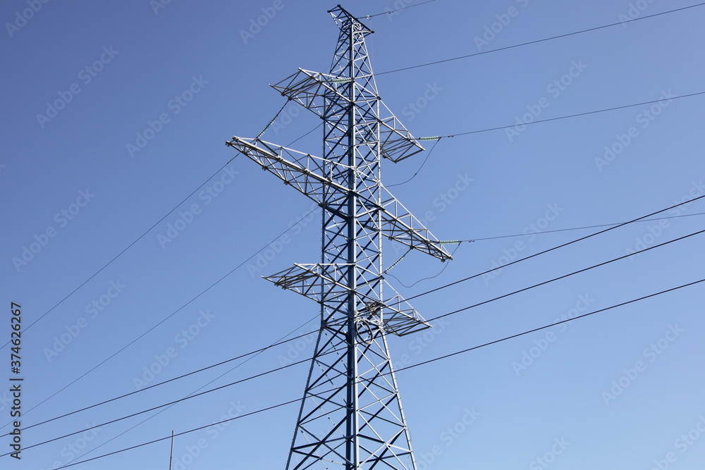 Big mast of an air power line closeup, new electricity pylon with wires and insulators on clear blue sky background, traditional energy, electric power energetic technology Big mast of an air power line closeup, new electricity pylon with wires and insulators on clear blue sky background, traditional energy, electric power energetic technology