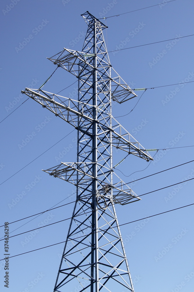 High electric power mast of an air power line closeup, new electricity pylon with wires and insulators on clear blue sky background, traditional energy net High electric power mast of an air power line closeup, new electricity pylon with wires and insulators on clear blue sky background, traditional energy net