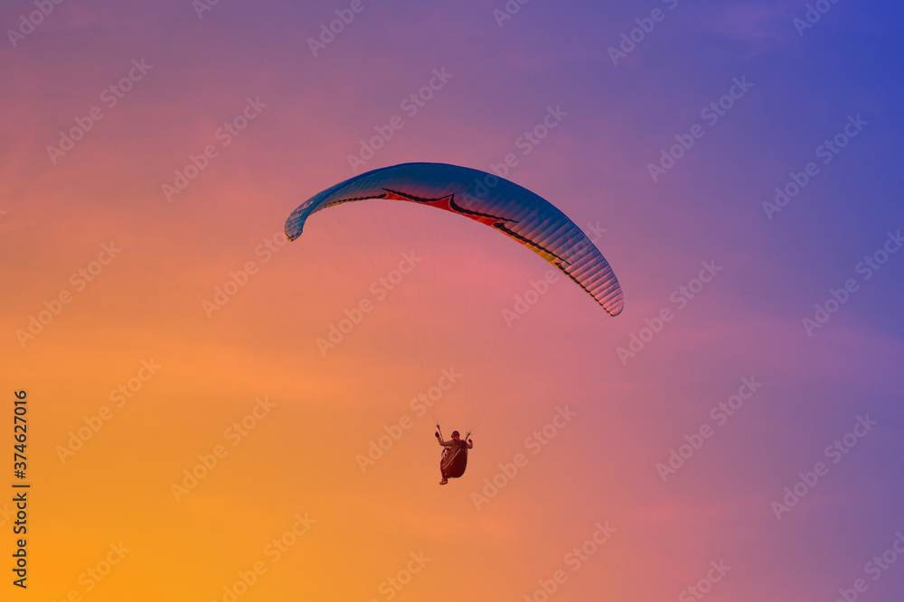 Paraglider flying on the res sky in sunset time in summer day. Cloud clear background. Paraglider flying on the res sky in sunset time in summer day. Cloud clear background.