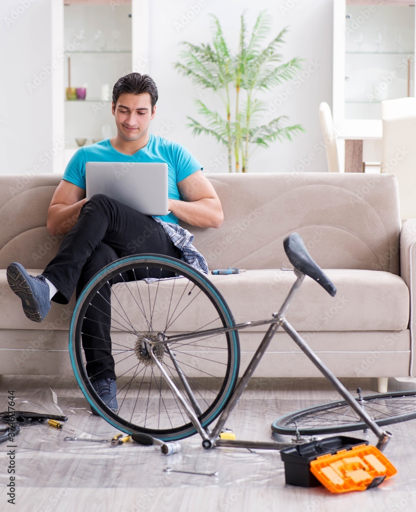Young man repairing bicycle at home Young man repairing bicycle at home