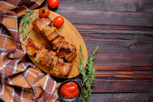 Skewers of Meat with sauce on wooden cutting board, ready to be served as summer party meal, view from above.