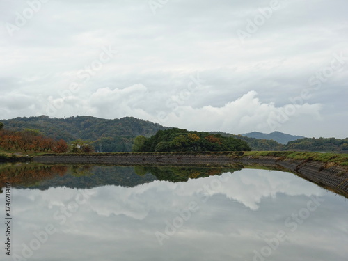 秋の風景を鏡のように写すため池