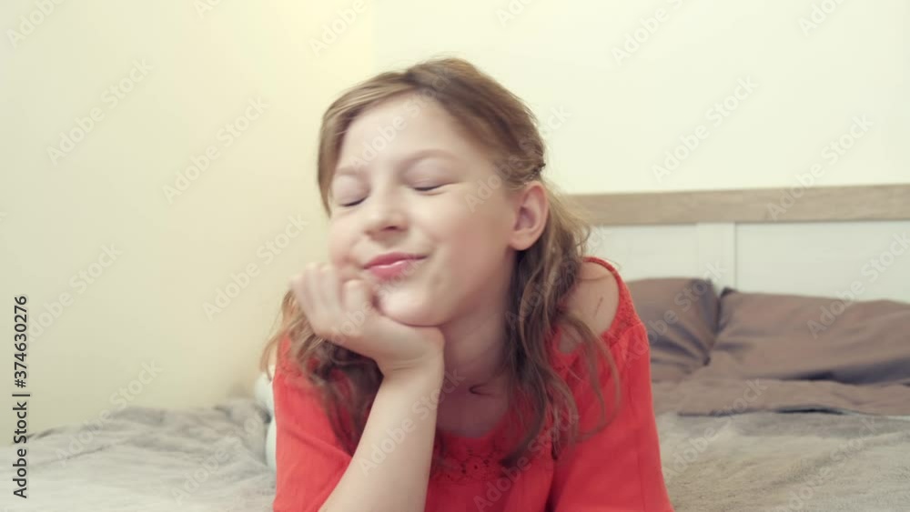 A girl lying on the bed sends an air kiss and looks at the camera. Online communication. Using applications for video communication. Conversation with a loved one. A girl lying on the bed sends an air kiss and looks at the camera. Online communication. Using applications for video communication. Conversation with a loved one.