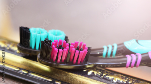 Two toothbrushes  so close  pink and green color.
