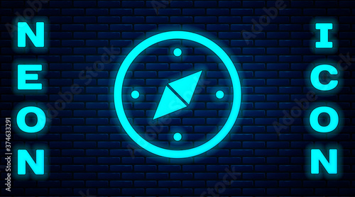 Glowing neon Compass icon isolated on brick wall background. Windrose navigation symbol. Wind rose sign. Vector.
