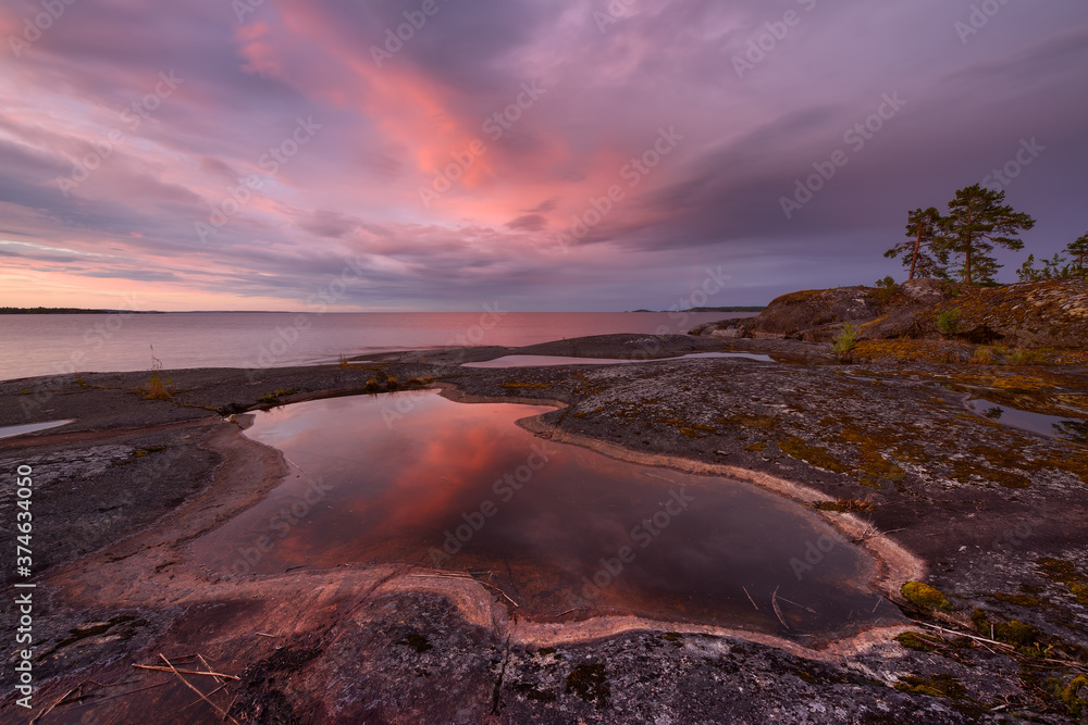 Rocky shore of the orthern lake at sunset, lake Ladoga