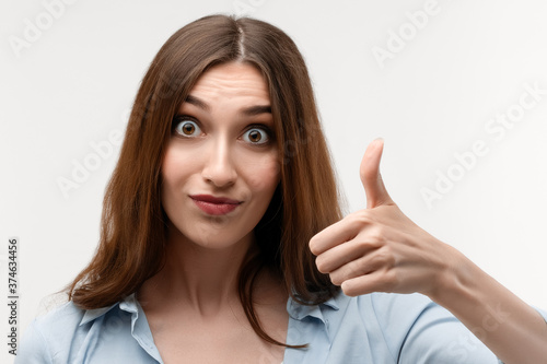 Wallpaper Mural Close up Caucasian Young female with long chestnut hair shows OKAY sign with hand, demonstrates approval Torontodigital.ca