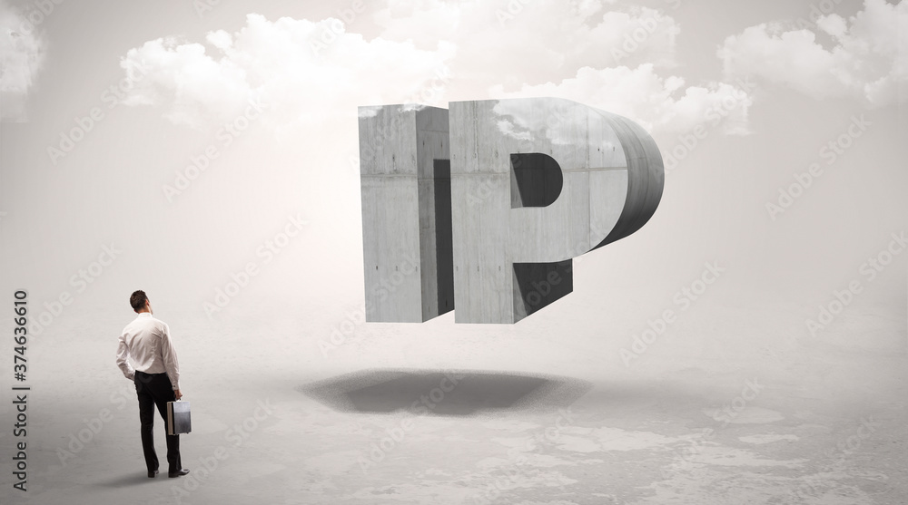 Fototapeta premium Rear view of a businessman standing in front of IP abbreviation, modern technology concept