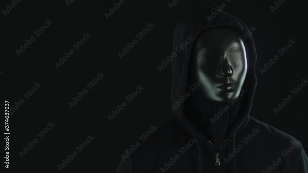 A man wearing black mask and clothes in front of glowing light bars A man wearing black mask and clothes in front of glowing light bars