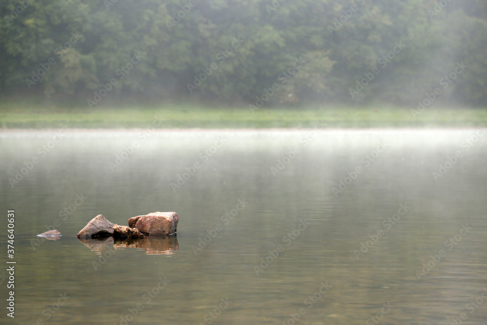 Fototapeta premium stones in the river in the fog