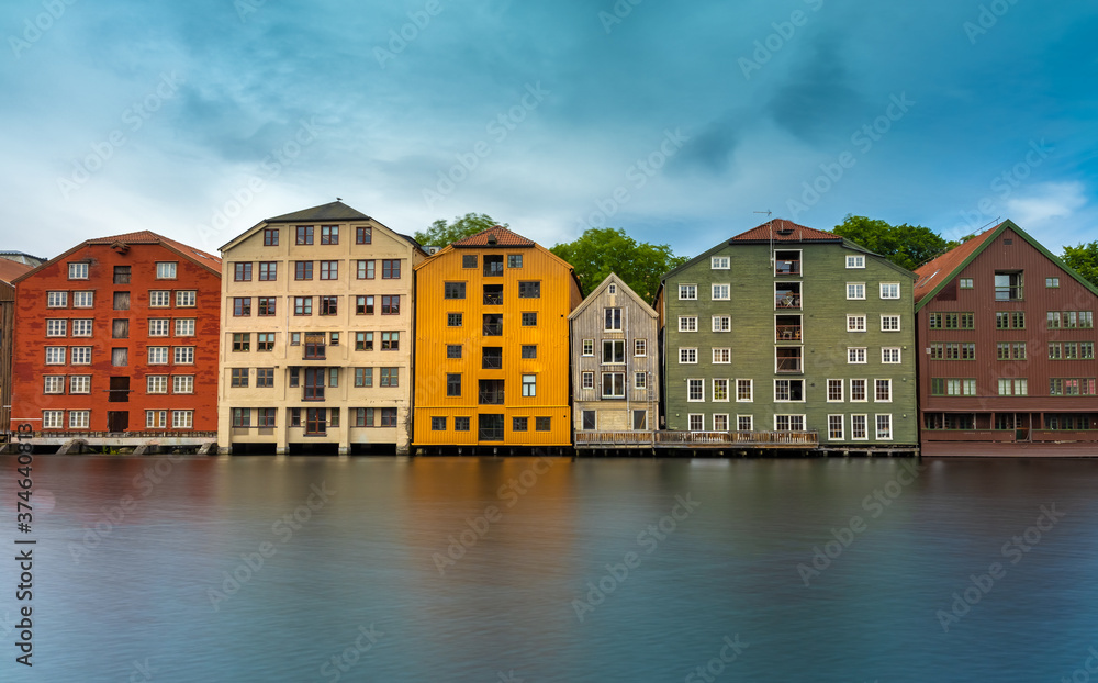The colorful and iconic old city wharves along the Nidelva river in Trondheim, Trondelag, Norway. Symbol of the historical role of Trondheim as a merchant city. The colorful and iconic old city wharves along the Nidelva river in Trondheim, Trondelag, Norway. Symbol of the historical role of Trondheim as a merchant city.