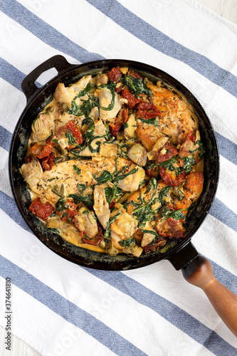 Homemade Creamy Tuscan Chicken in a cast-iron pan, top view. Flat lay, overhead, from above.