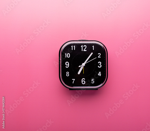 Alarm clock isolated on pink background. Morning waking up and time concept