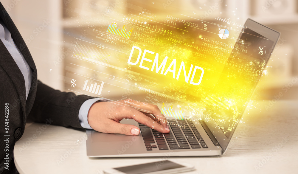 Closeup of businessman hands working on laptop with DEMAND inscription, succesfull business concept Closeup of businessman hands working on laptop with DEMAND inscription, succesfull business concept