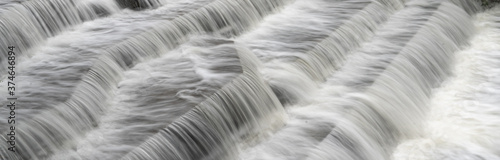 White Water flowing over weir low-level view at long exposure for blurred water effects and textures 