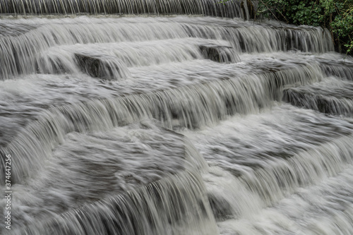 White Water flowing over weir low-level view at long exposure for blurred water effects and textures 