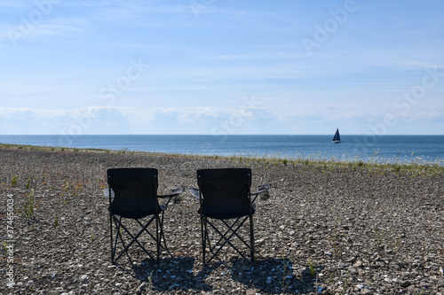 Waterfront view from two chairs by the coast photo