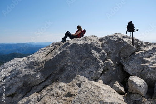 Mountain view with silhouette of resting tourist woman in viewpoint in beautiful National Park Risnjak, Croatia photo
