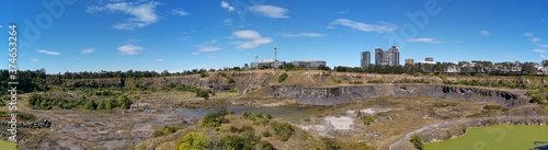 Beautiful panoramic view of a historic brick pit with blue sky, light clouds and buildings in the background, Bicentennial park, Sydney Olympic Park, Sydney, New South Wales, Austral