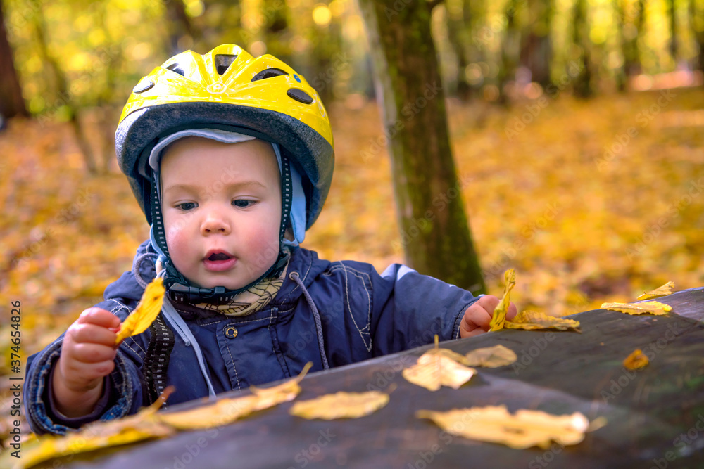 Autumn is here. Cute smiling baby boy with safety helmet in the autumn park. Autumn is here. Cute smiling baby boy with safety helmet in the autumn park.