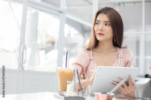 Free Download Protrait of Beautiful businesswoman sitting at desk and working with laptop smartphone and computer. - GFXLoad