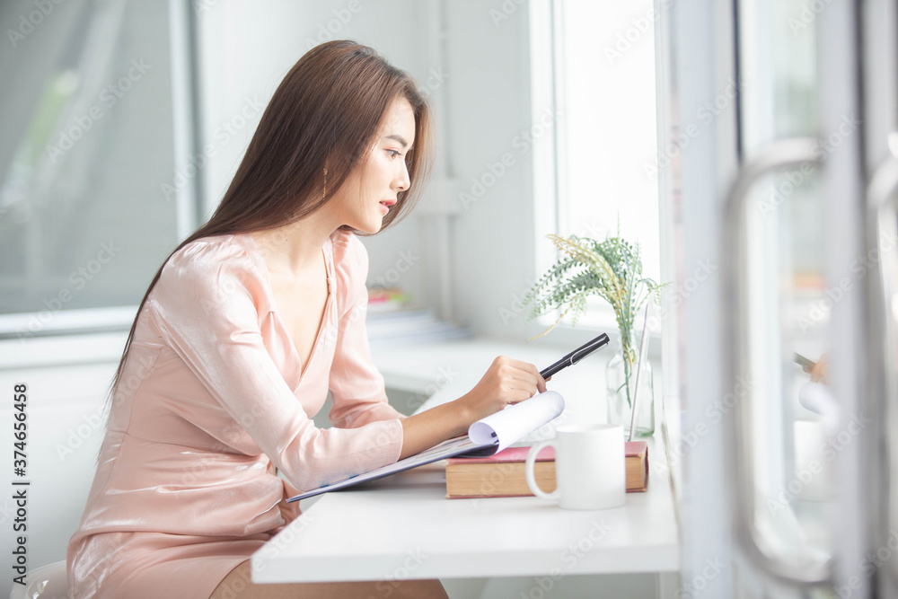 Protrait of Beautiful businesswoman sitting at desk and working with laptop smartphone and computer. Protrait of Beautiful businesswoman sitting at desk and working with laptop smartphone and computer.