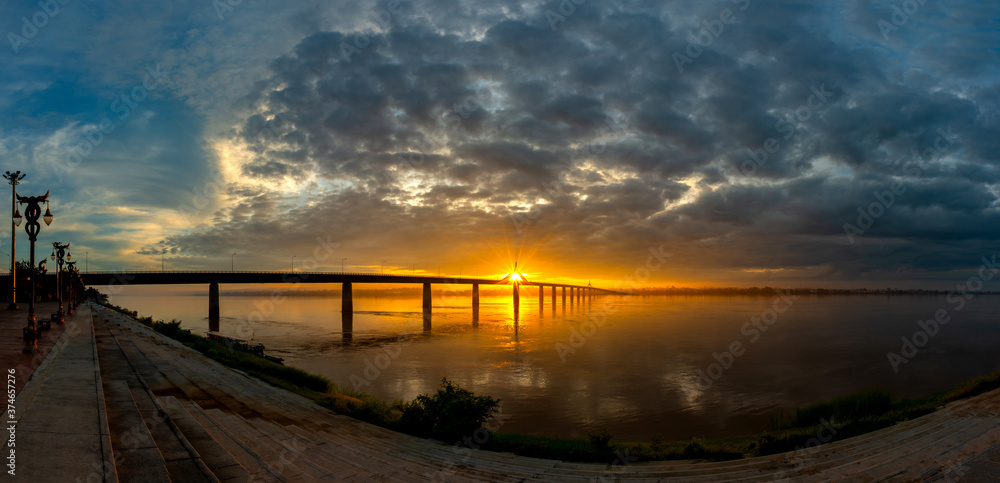 Panorama Beautiful sky on twilight time and Sunlight through the bridge on the river and silhouette of the Second Thai–Lao Friendship Bridge of Thailand and 
 Laos.