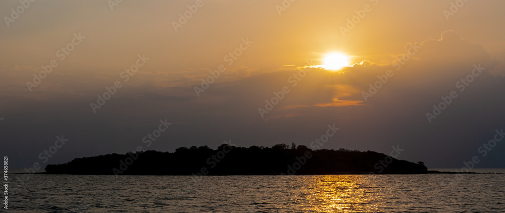 A small island in the Gulf of Thailand in backlight from the sunset.