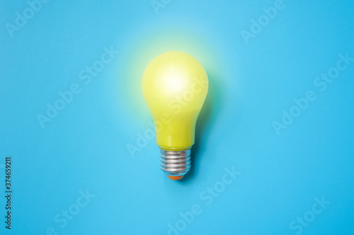 Valokuvatapetti Bright yellow light bulb isolated on light blue background ,new idea ,innovation