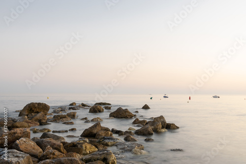 Rocks bathed by a calm sea on the beach of Almuñecar. Long exposure.