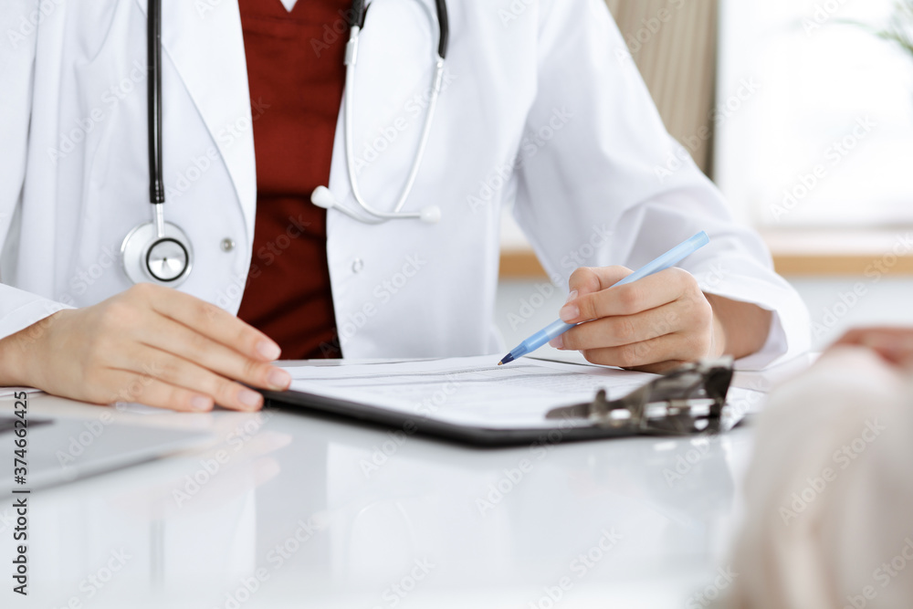 Unknown woman-doctor consulting patient and using clipboard with a medication history record. Medicine concept Unknown woman-doctor consulting patient and using clipboard with a medication history record. Medicine concept