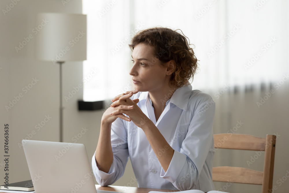 Thoughtful woman doctor sitting at work desk with laptop, pondering problem solution, pensive therapist physician gp wearing white coat lost in thoughts, planning treatment, online research Thoughtful woman doctor sitting at work desk with laptop, pondering problem solution, pensive therapist physician gp wearing white coat lost in thoughts, planning treatment, online research