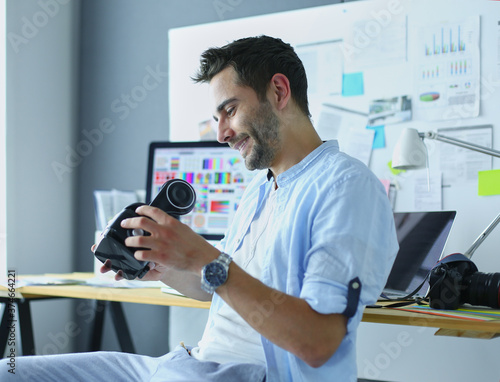 Young male software programmer testing a new app with 3d virtual reality glasses in office. photo