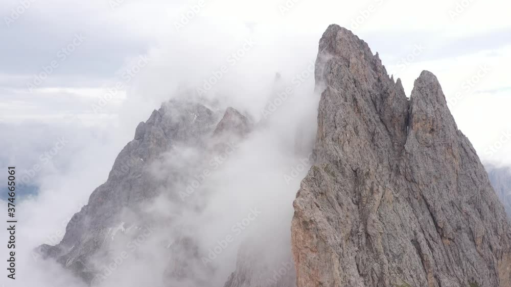 Rotating drone shot of stark mountain peaks of the Seceda ranges covered in mist, natural landscape in the Dolomite mountains in Italy
Rotating drone shot of stark mountain peaks of the Seceda ranges covered in mist, natural landscape in the Dolomite mountains in Italy