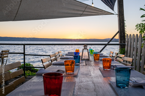Tableau sur toile Dinner table during sunset near the beach. Bolsena Italy
