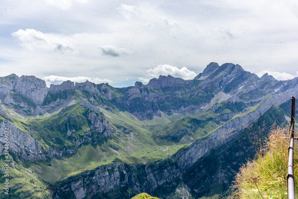 Fototapeta premium The steep path leading to the majestic Schaefler peak in the Alpstein mountain range around the Aescher cliff in Appenzell, Switzerland