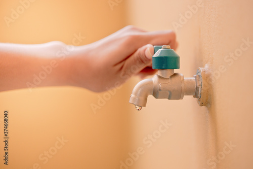 A woman's hand is opening or closing the water from the tap for cleaning. photo