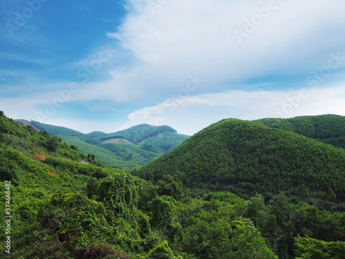 The green mountain range over blue sky background.
