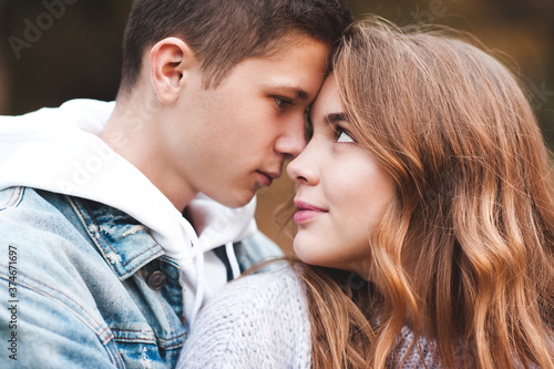 Teen boy and girl 15-16 year old looking at each other closeup. Relationship. Autumn season. Happiness. © morrowlight