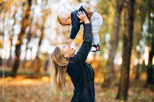 Fotografie Happy mother with her little baby son have fun in the city park