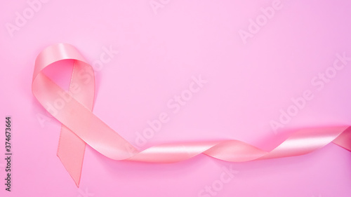 Top view of Pink ribbon on pink background with copy space, Breast cancer symbol, Breast cancer awareness month. Important days in October