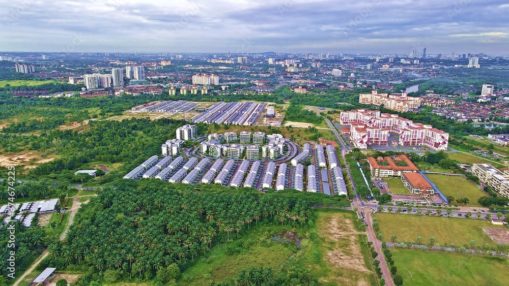 Aerial view of an esteemed condominium luxurious living overlooking the surrounding greeneries and partly cloudy skies