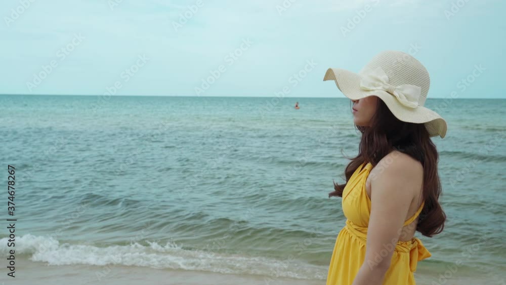 young woman in yellow dress walking on the sea beach young woman in yellow dress walking on the sea beach