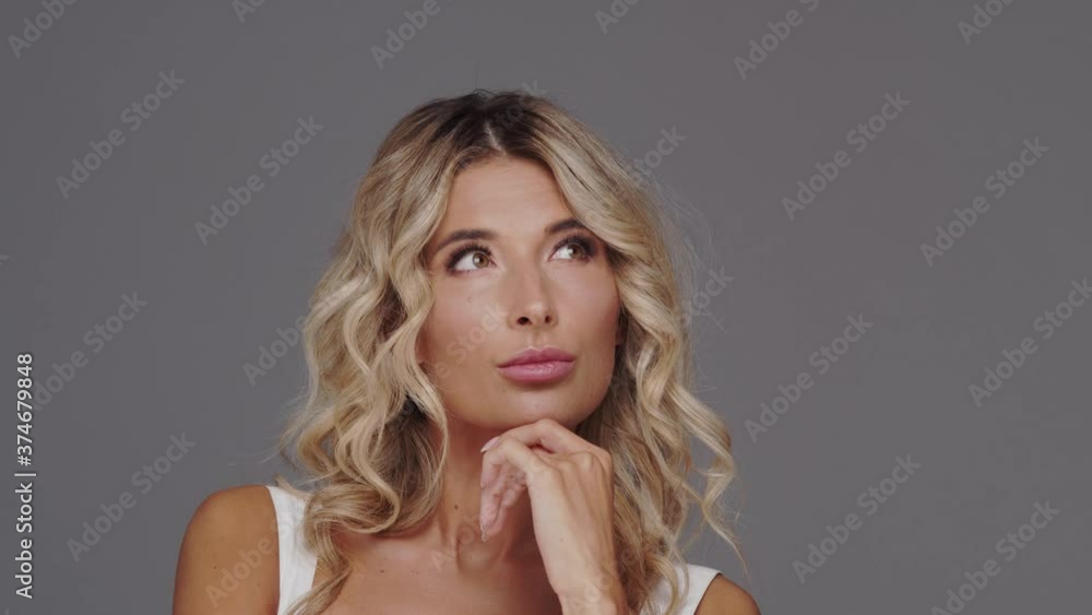 Studio portrait of young and beautiful blond woman over grey background. Studio portrait of young and beautiful blond woman over grey background.
